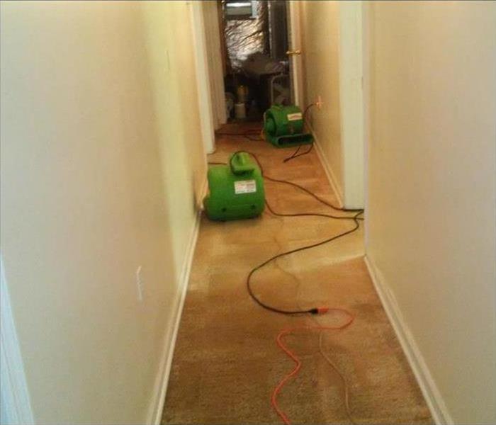 Two air movers placed in the hallway of a building