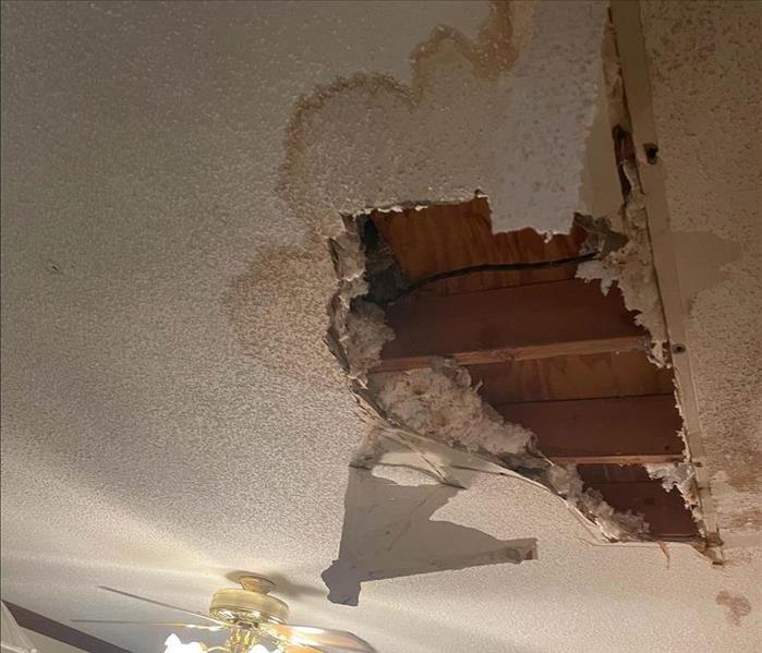 Hole in ceiling due to water damage.