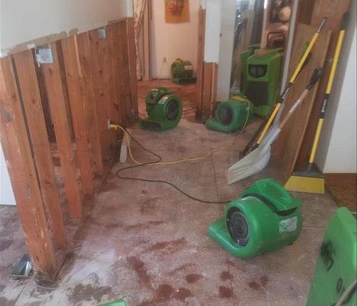Broom, shovel, air movers placed in a home, flood cuts performed on a drywall.